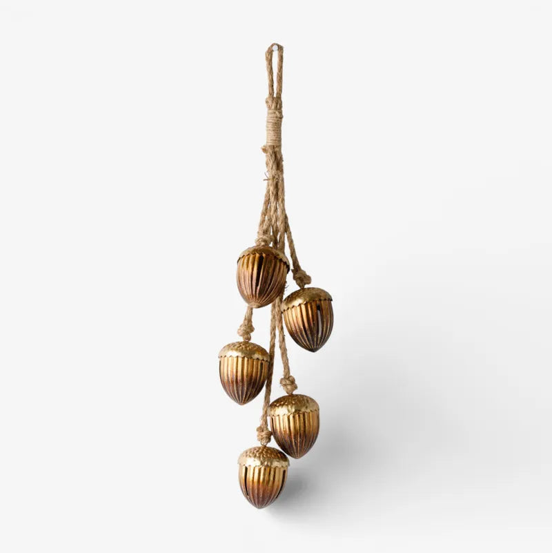 Decorative hanging with gold acorn-like ornaments on a white background