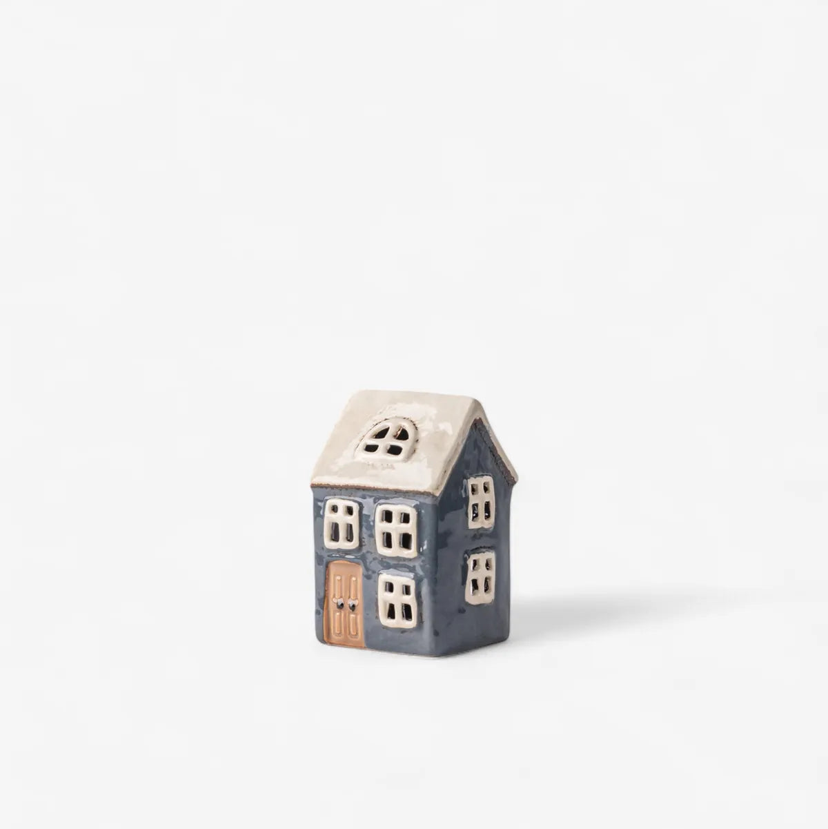 Small ceramic house-shaped object on a white background