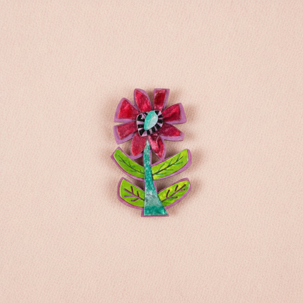 Colorful flower-shaped brooch on a pale pink background