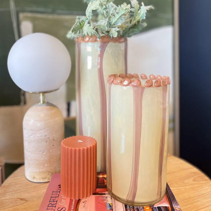 Decorative items including a lamp, candles, and vases on a table with a blurred background.