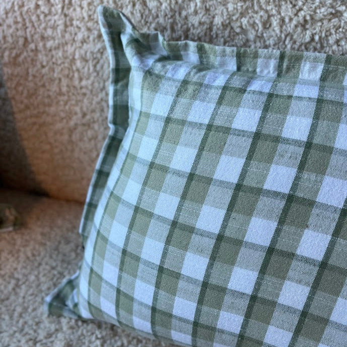 Green and white checkered pillow on a beige sofa