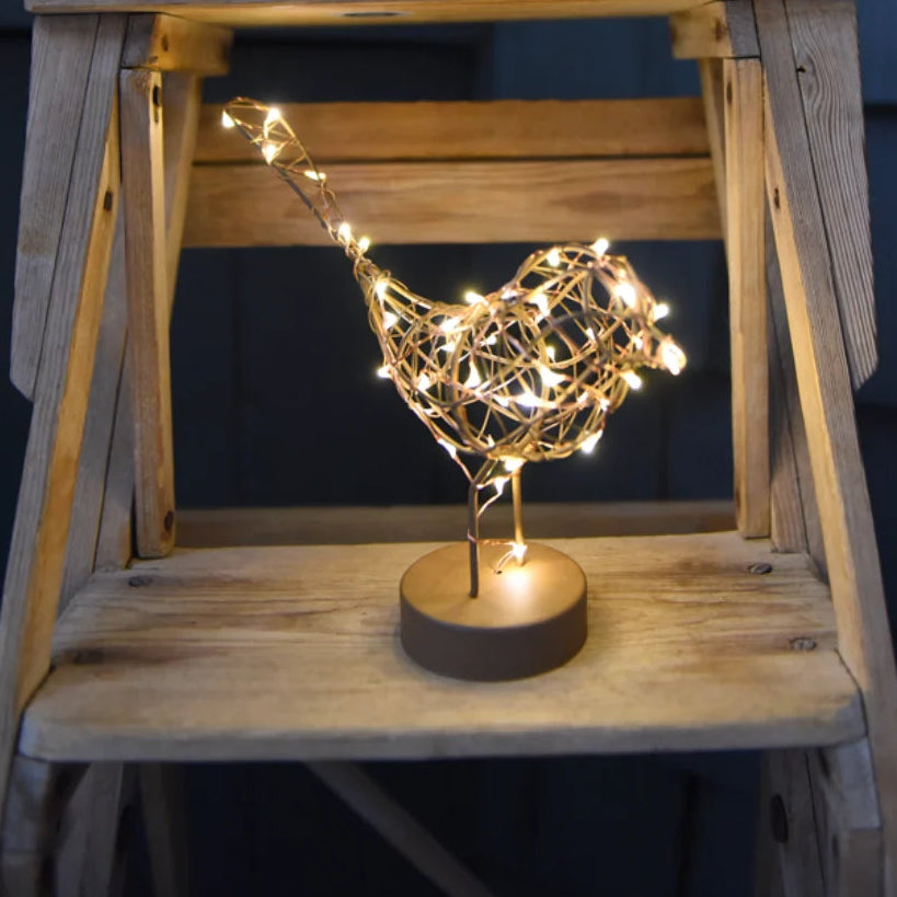 Decorative light fixture shaped like a bird on a wooden stand