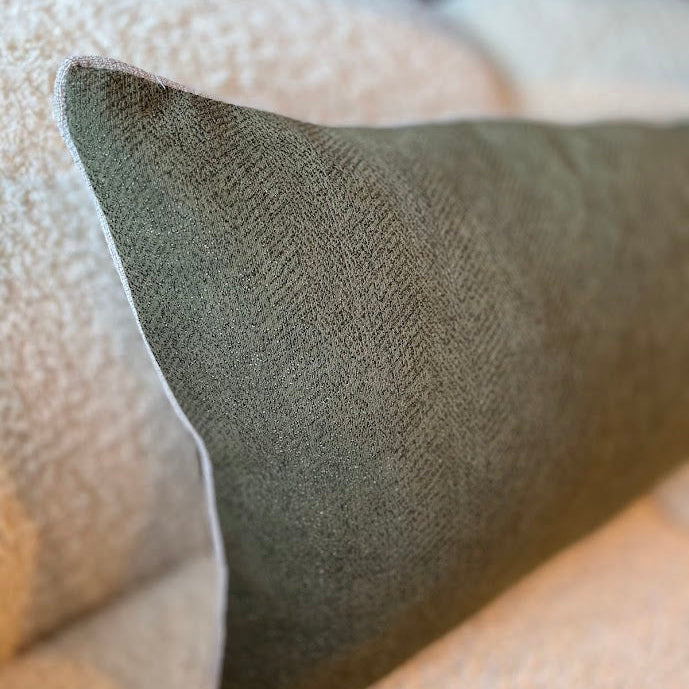 Close-up of linen chenille lumbar cushion in Moss on a boucle lounge