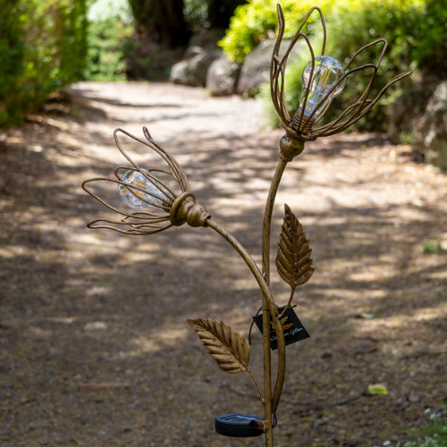 Decorative metal flower with solar lights on a garden path