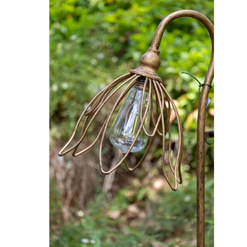 Decorative outdoor light fixture with a floral design against a natural background