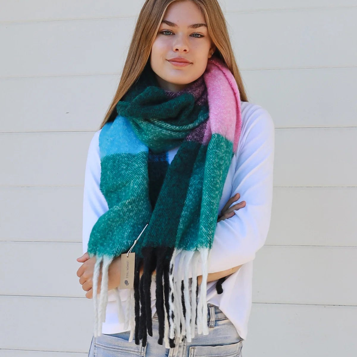 Woman wearing a colorful scarf with a white wall background