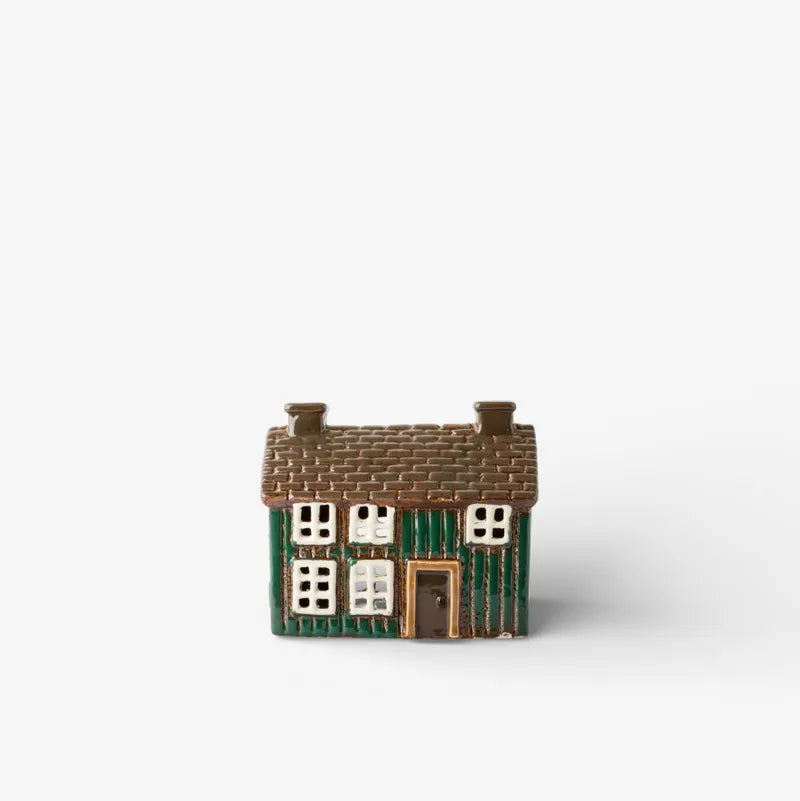 Small model of a house with a green base and brown roof on a white background
