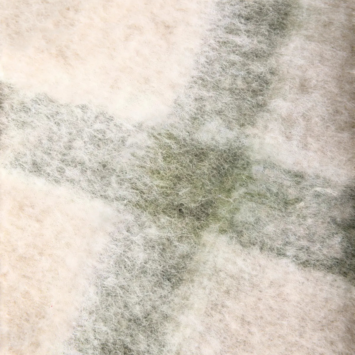 Close-up of a textured fabric green and beige throw