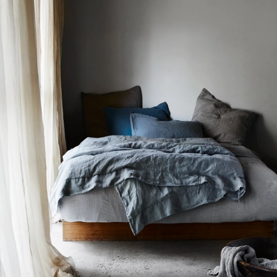 linen bedding blue grey charcoal styled on a bed next to a window