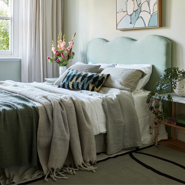 linen sheets in grey, blue, aqua styled on a bed