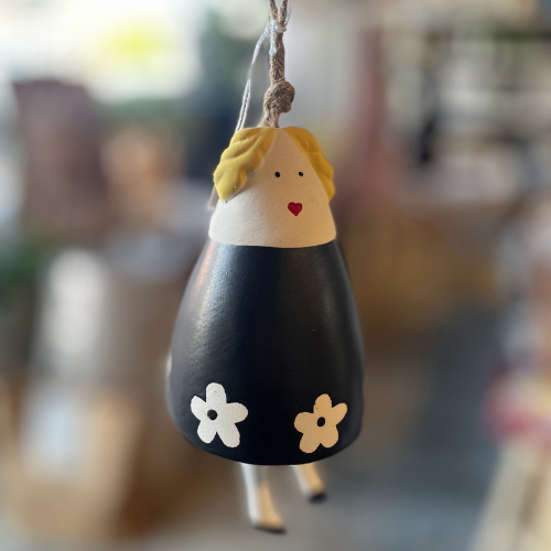 Decorative bell with a face and flowers on a blurred background