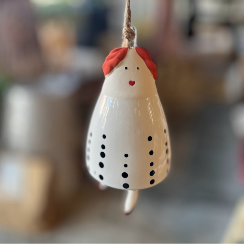 Decorative hanging bell with red hair and black dots on a blurred background
