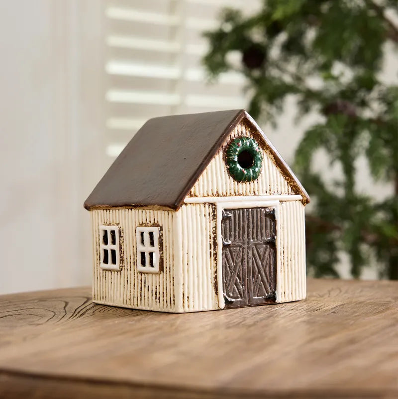 Small wooden house model with a wreath on a wooden surface