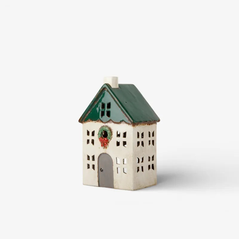 Small ceramic tealight house with a green roof on a white background
