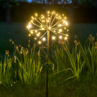 Decorative outdoor light fixture shaped like a flower in a garden at night.