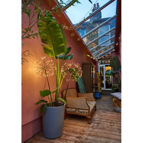 Outdoor flower-shaped stake lights in a potted plant on a patio