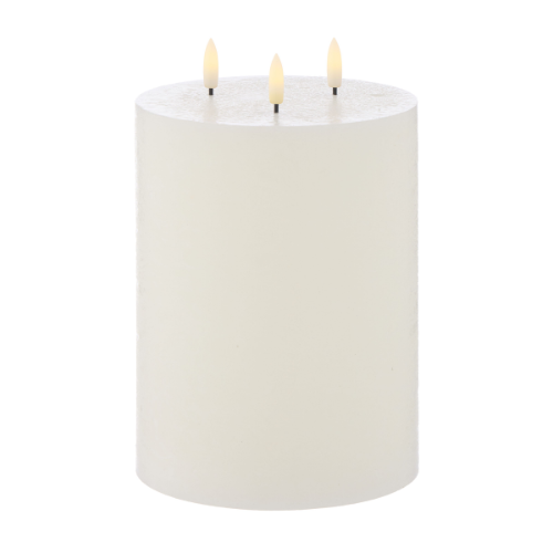 White candle with three lit wicks on a white background