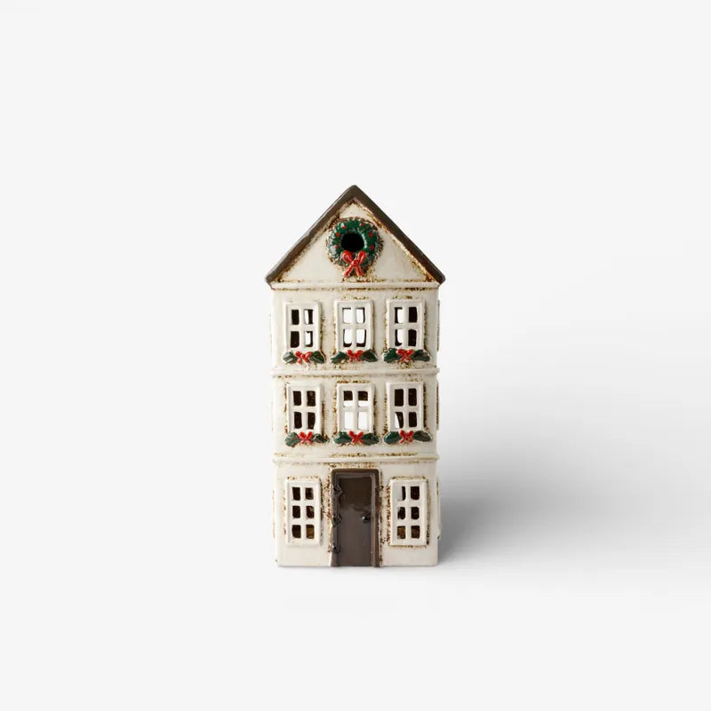 Ceramic tealight house with a wreath on a white background
