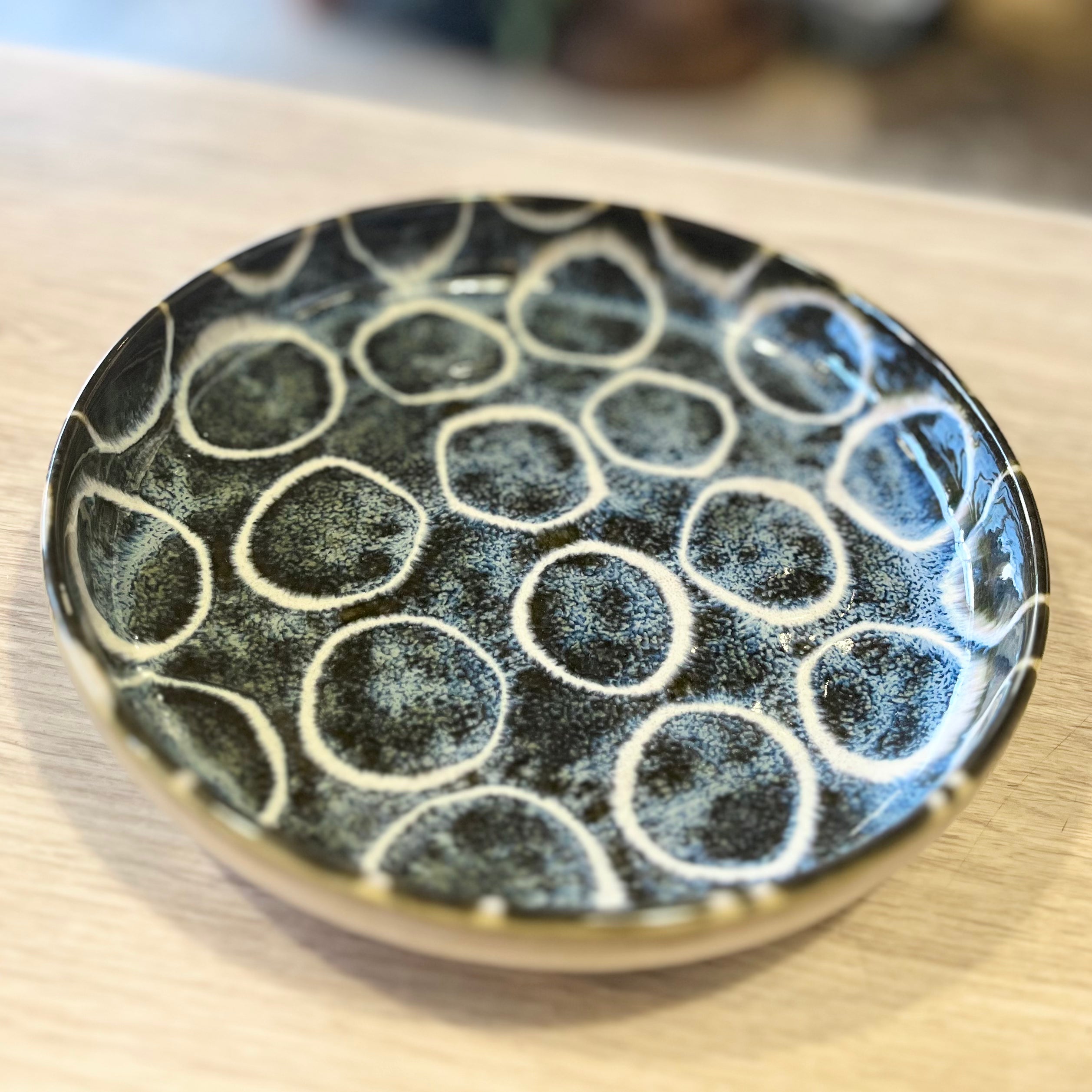 Ceramic bowl with circular pattern on a wooden surface