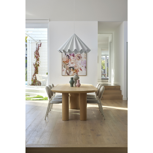 Modern dining room with wooden table and chairs, featuring a decorative painting on the wall.