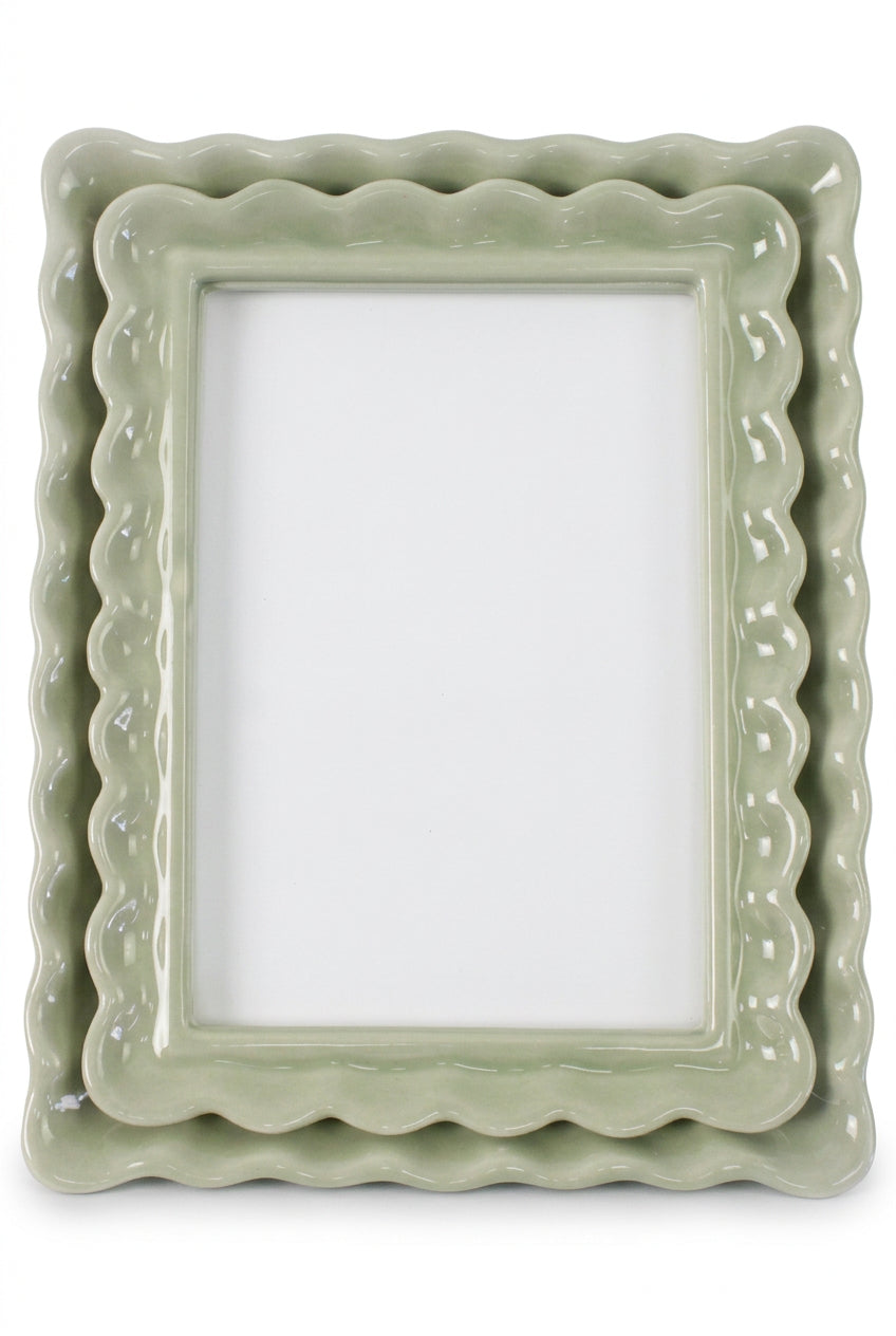 A light sage green ceramic picture frame with a wavy scalloped border, shown on a clean white background. 