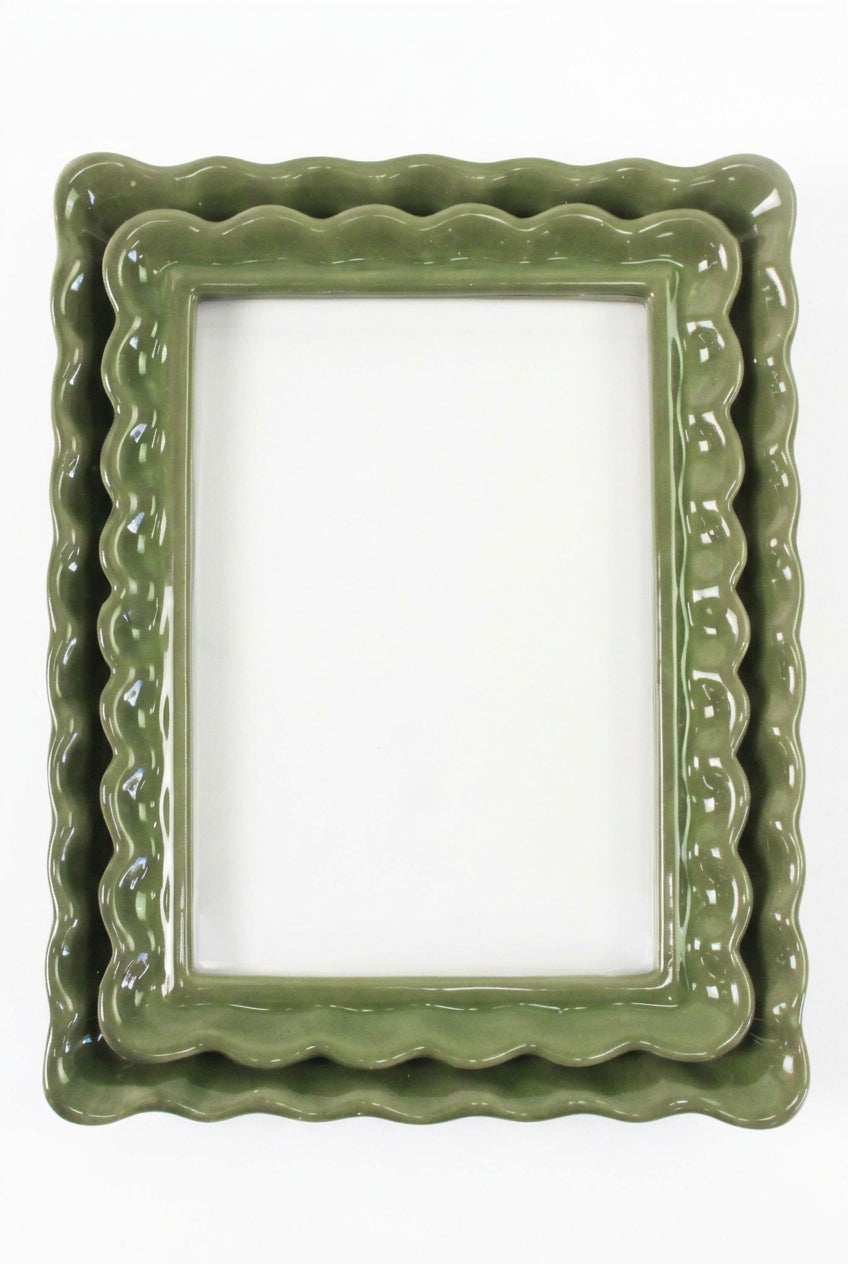 A green ceramic photo frame with a scalloped border, shown on a white background. 