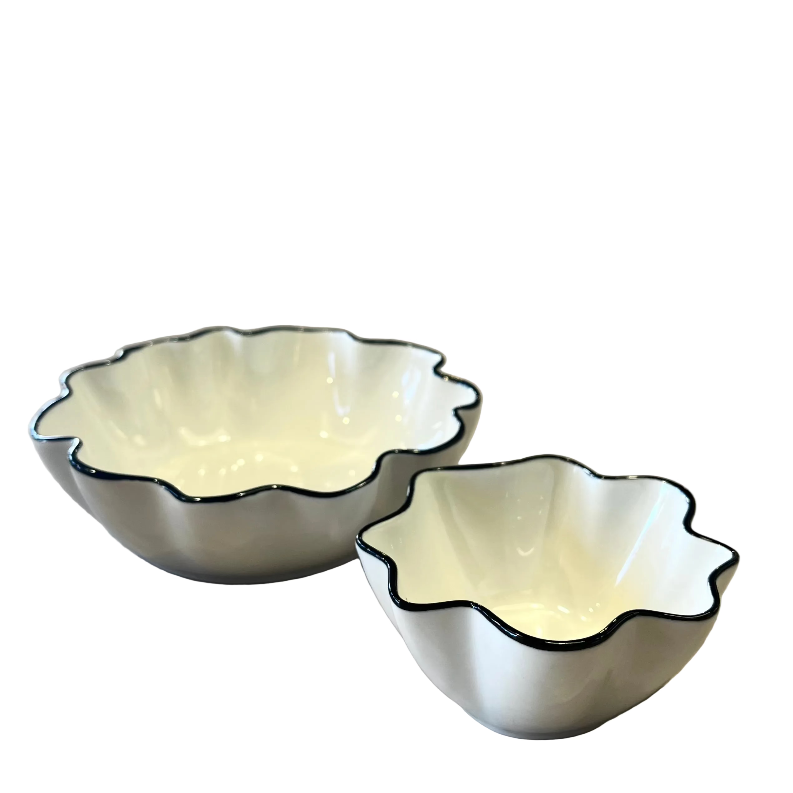 Two white ceramic bowls with black rims on a wooden surface, blurred background