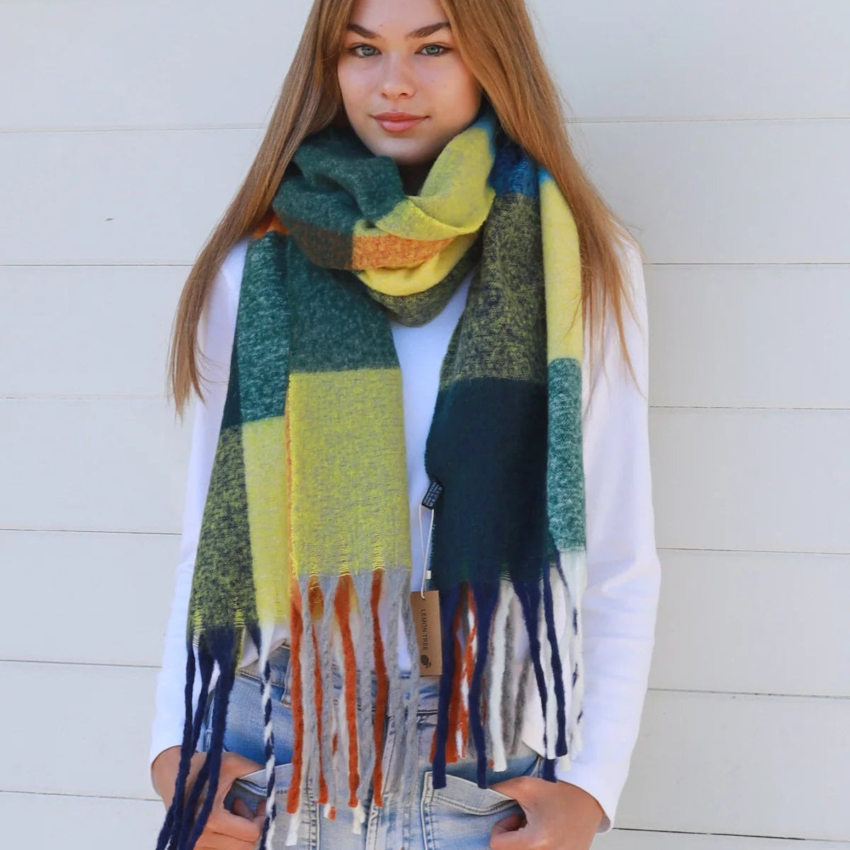 Person wearing a colorful scarf against a white wall