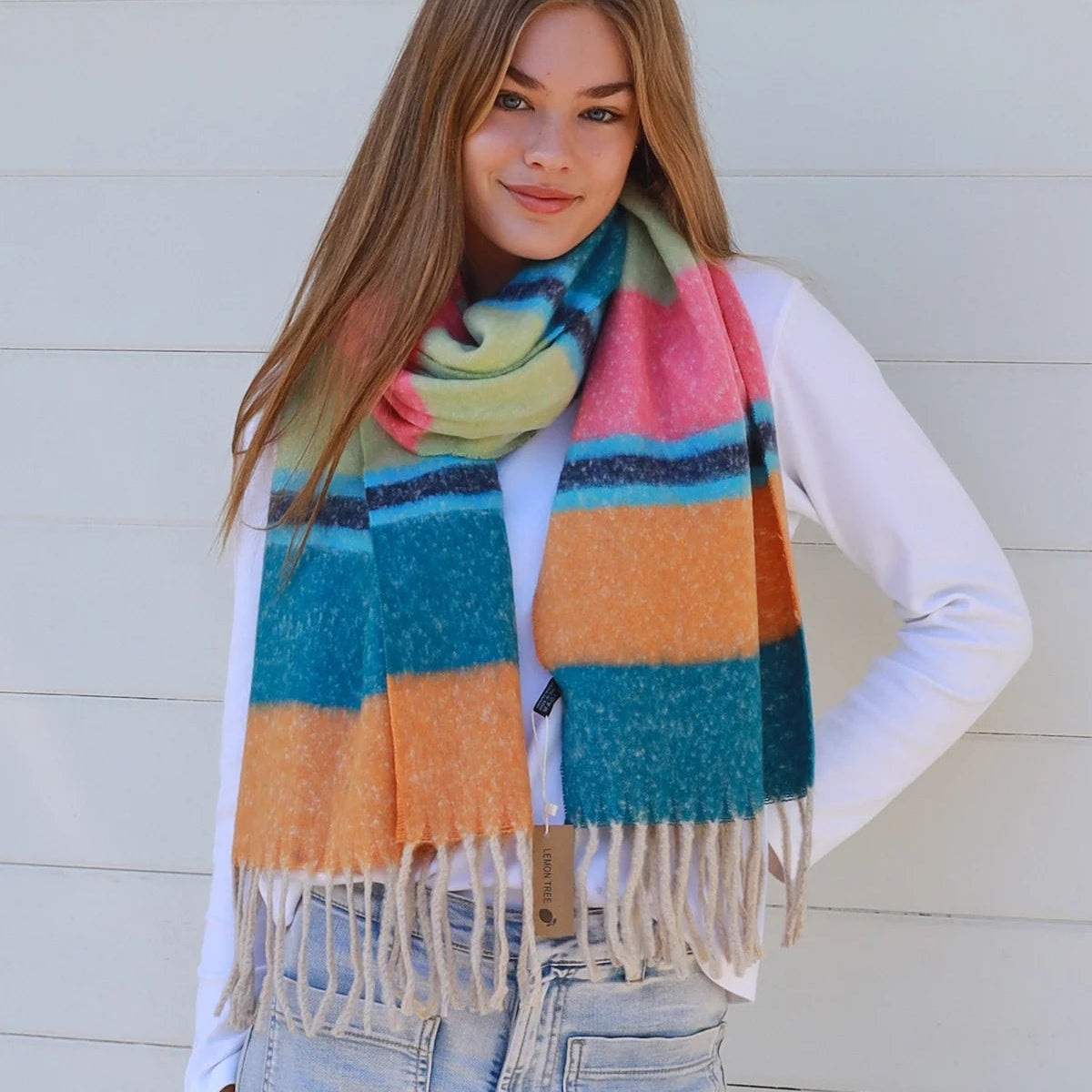 Woman wearing a colorful striped scarf against a light background