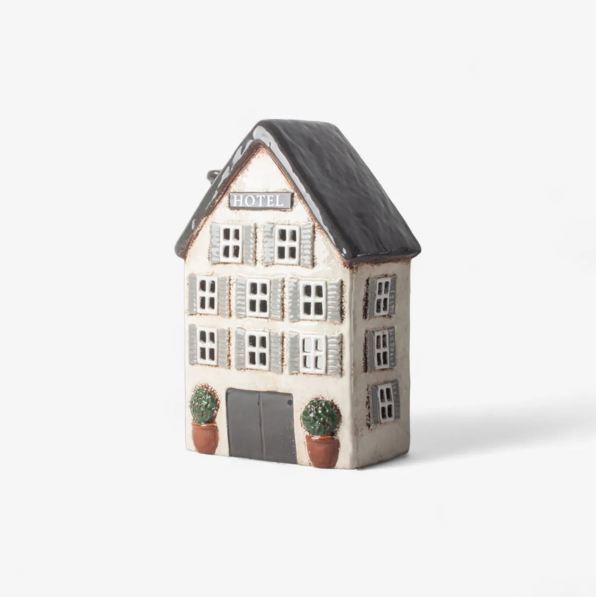Decorative tea light house with a black roof on a white background