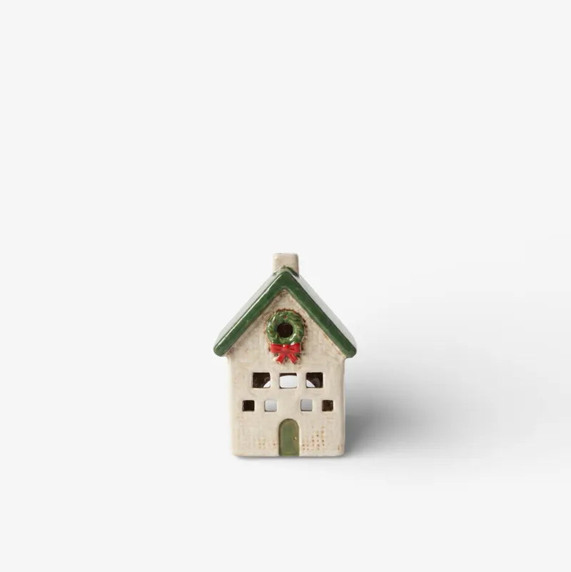 Small decorative house with a green roof on a white background