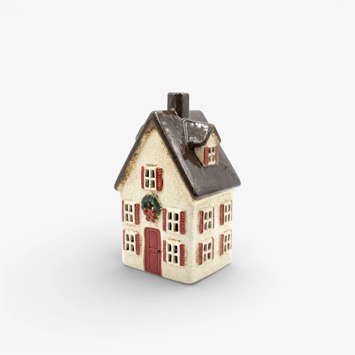 Small decorative house with a white base and brown roof on a light gray background