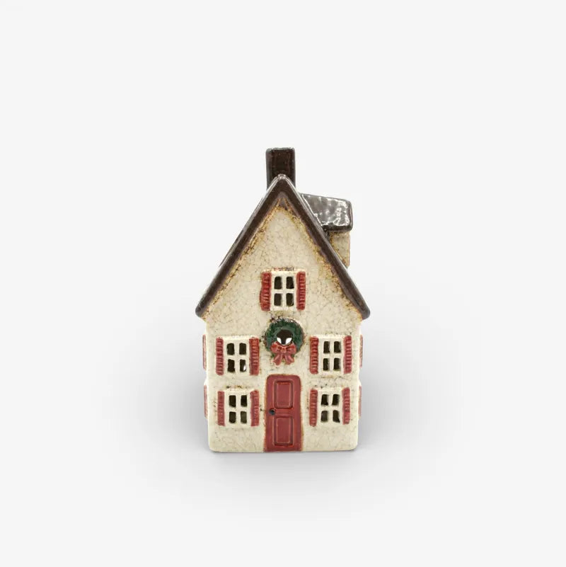 Small decorative house with a red door on a white background
