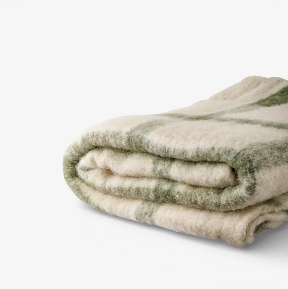 Folded blanket with green and beige pattern on a white background