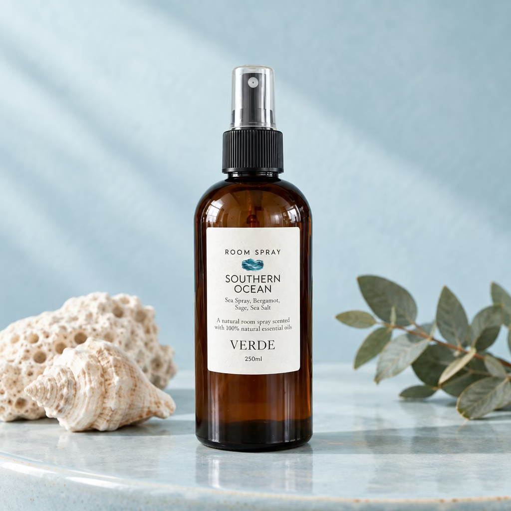 A 50ml room spray bottle labelled 'Southern Ocean' Room Spray by Verde, made from amber glass with a black spray cap and white label, set on a marble countertop with a potted green plant and tiled wall in the background.