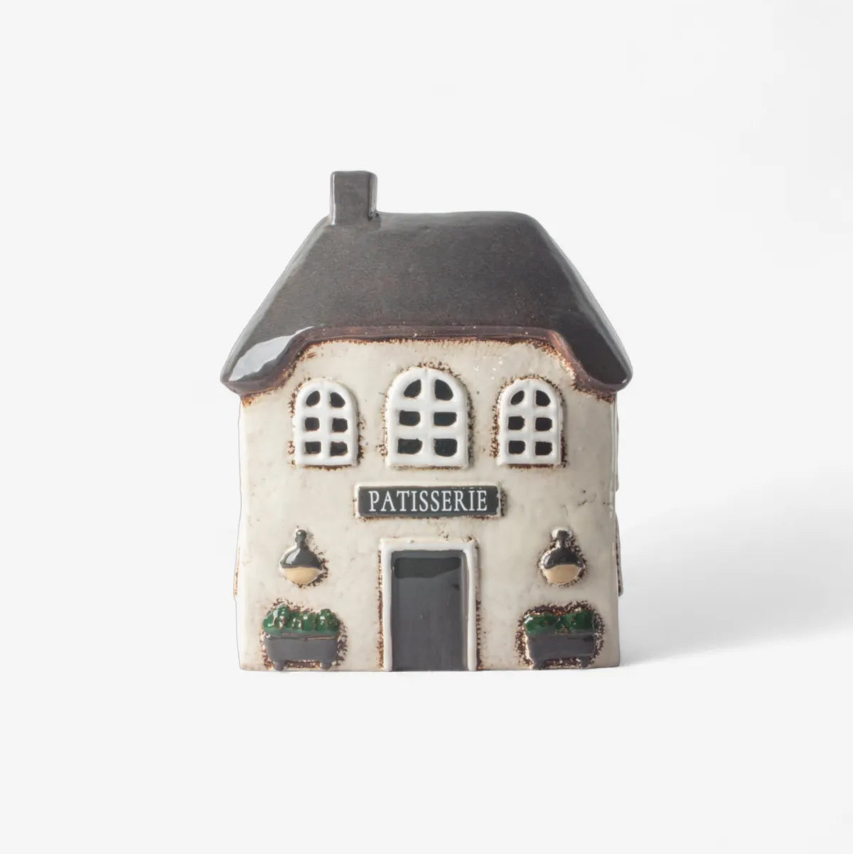 Small ceramic house model with 'Patisserie' sign on a white background