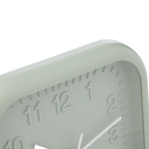 Sage green clock with white numbers and hands on a white background