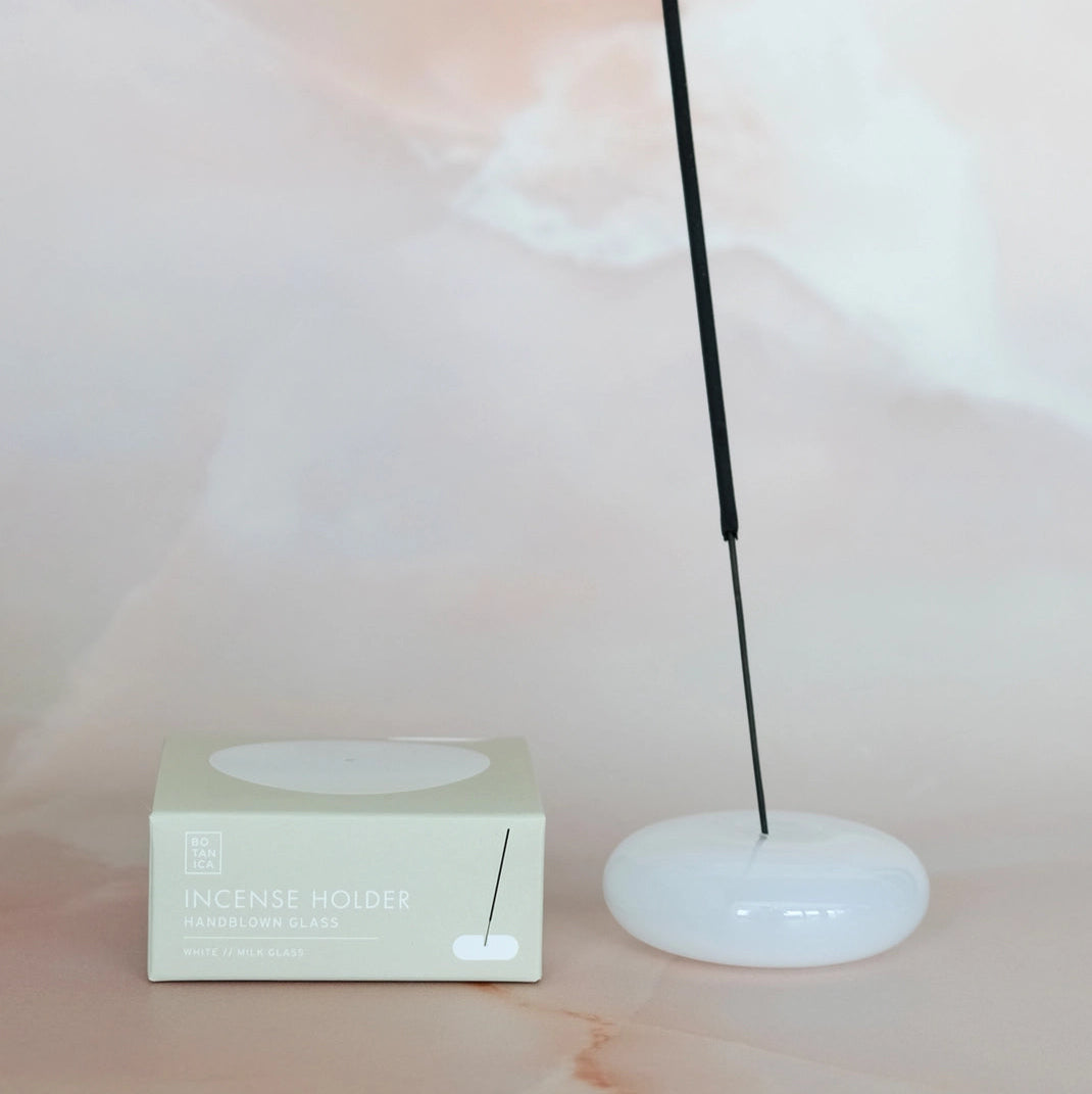 White incense holder with a box on a soft pink background