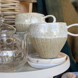 handmade speckled mugs stacked with a raw stoneware base and ivory glaze on the inside, upper outside, and handle,  and handle 
